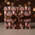 Boho western wrapping paper with bull skulls and pink roses by Wrapped Studios, tied with a brown satin bow.