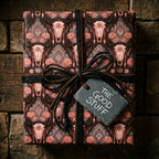 Rustic western steer skull wrapping paper by Wrapped Studios, tied with black twine and a slate tag.