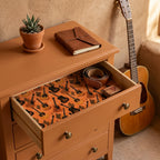 Rustic guitar and cactus wrapping paper by Wrapped Studios lining a terracotta drawer.