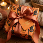 Acoustic guitar wrapping paper on a rustic gift box with a copper bow by Wrapped Studios.