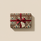 Rustic wrapping paper featuring a Southwest desert print, tied with a burgundy ribbon, for birthday gifts or special occasions.