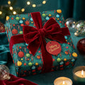Festive Christmas gift wrap: Teal paper with ornaments, tied with a red velvet ribbon.