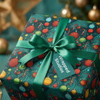 Wrapped Studios Christmas gift wrap. Dark green paper with ornament and candy cane pattern, tied with satin ribbon.
