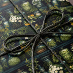Botanical wrapping paper with dark cord.