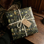 Square gift wrapped in botanical jars paper with twine bow and tag.