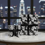 Two elegant gifts wrapped in black & white leaf-patterned paper with black satin ribbons, city skyline background.