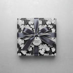 Elegant gift box wrapped in black & white floral wrapping paper with gray satin ribbon.