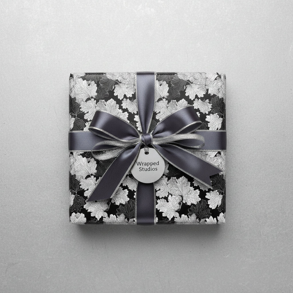 Elegant gift box wrapped in black & white floral wrapping paper with gray satin ribbon.