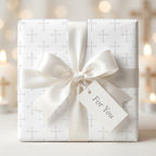 Elegant white cross baptism wrapping paper with a cream satin bow and tag by Wrapped Studios.