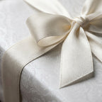 Elegant wedding wrapping paper with white damask pattern and ivory satin bow by Wrapped Studios.