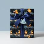 Cute baby shower wrapping paper featuring ducklings and string lights, tied with a navy blue satin ribbon.