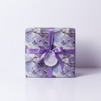 Elegant gift box wrapped in floral wrapping paper with a lilac ribbon and "A Small Token" tag.