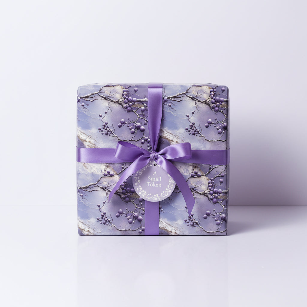 Elegant gift box wrapped in floral wrapping paper with a lilac ribbon and "A Small Token" tag.