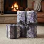 Elegant gifts wrapped in purple floral wrapping paper with gray ribbons, set by a fireplace.