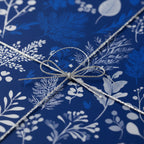 Navy blue floral wrapping paper tied with silver string bow.