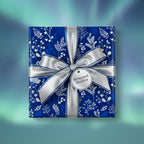 Elegant floral wrapping paper in deep blue with silver ribbon and bow.