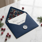 Elegant navy blue winter wedding invitation envelope with holly floral liner by Wrapped Studios.