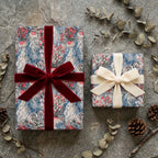 Luxury holiday wrapping paper with red and cream velvet bows, pinecones on stone by Wrapped Studios.