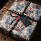 Coastal jellyfish wrapping paper on a gift tied with twine and 'From the Ocean' tag, by Wrapped Studios.
