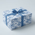 Rectangular gift wrapped in abstract blue wrapping paper with matching ribbon.