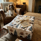 Personalized dog wrapping paper featuring spaniel pattern and cream ribbon by Wrapped Studios.