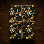 Elegant Christmas gift wrap with green and white striped ribbon, ornaments, and rustic twine tie.