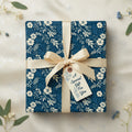 Navy blue floral wrapping paper with tan ribbon and "A Special Gift For You" tag.