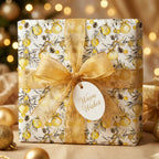 Luxury gold Christmas wrapping paper with festive ornament pattern and ribbon by Wrapped Studios.