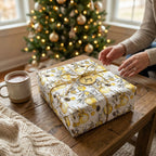 Yellow floral Christmas wrapping paper with gold twine and a "Joy" tag by Wrapped Studios.