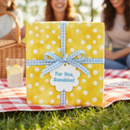 Playful yellow polka dot gift wrap with blue gingham ribbon and "For You, Sunshine!" tag, perfect for a baby shower or birthday.